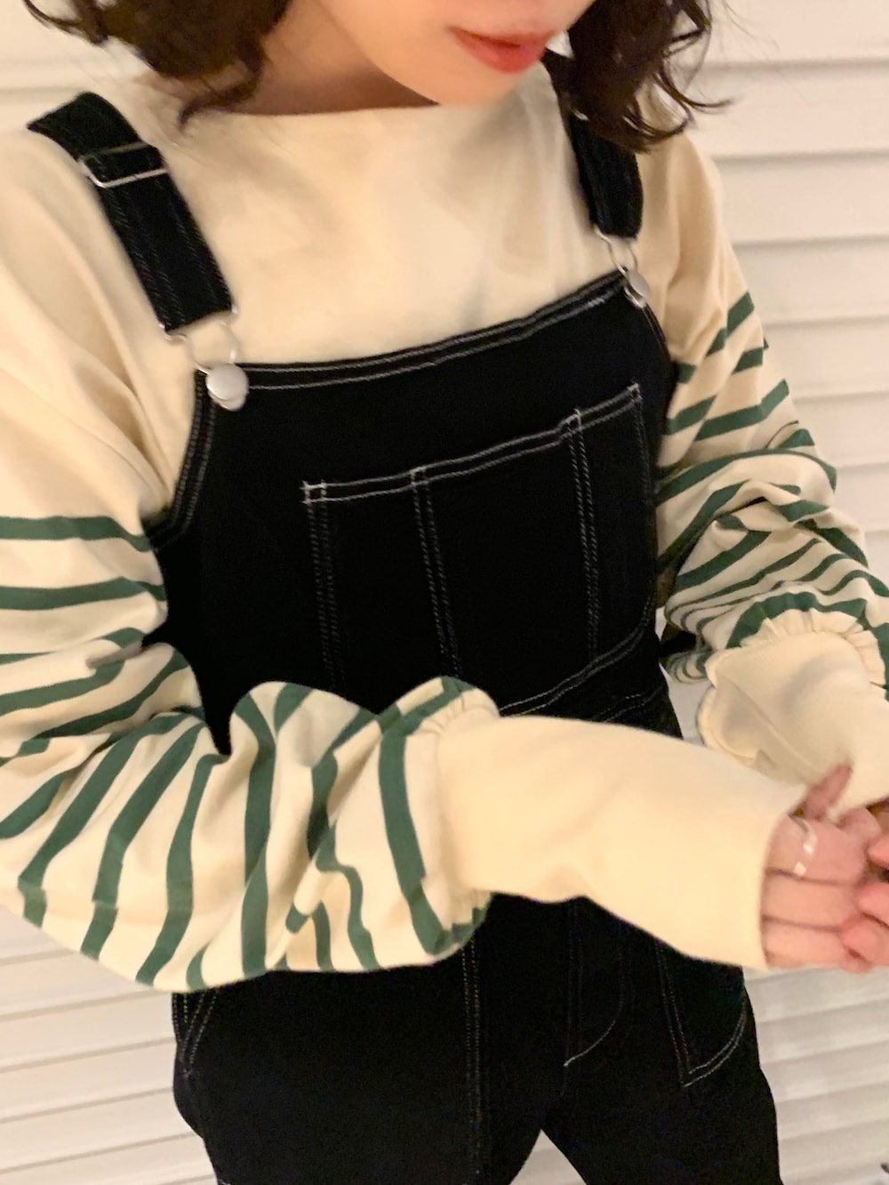 ブラック系のサロペット/オーバーオール、グリーン系のTシャツ/カットソーを着用したレディースの春コーディネートの2枚目の写真