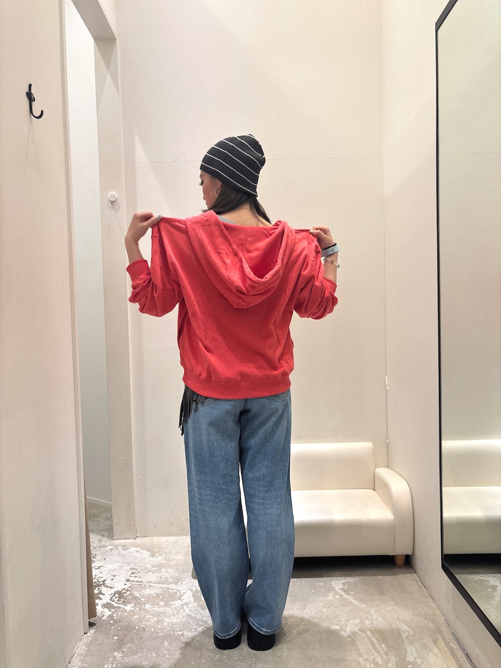 ピンク系のパーカー、ブルー系のデニムパンツ、ブラウン系のストール/ショールを着用したレディースの秋コーディネートの2枚目の写真