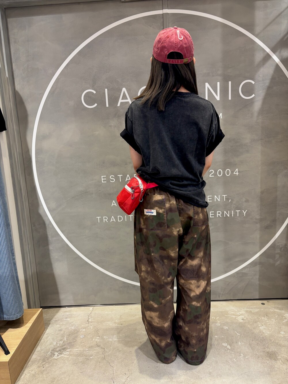 ブラック系のTシャツ/カットソー、その他のパンツ、レッド系のキャップを着用したレディースの夏コーディネートの2枚目の写真