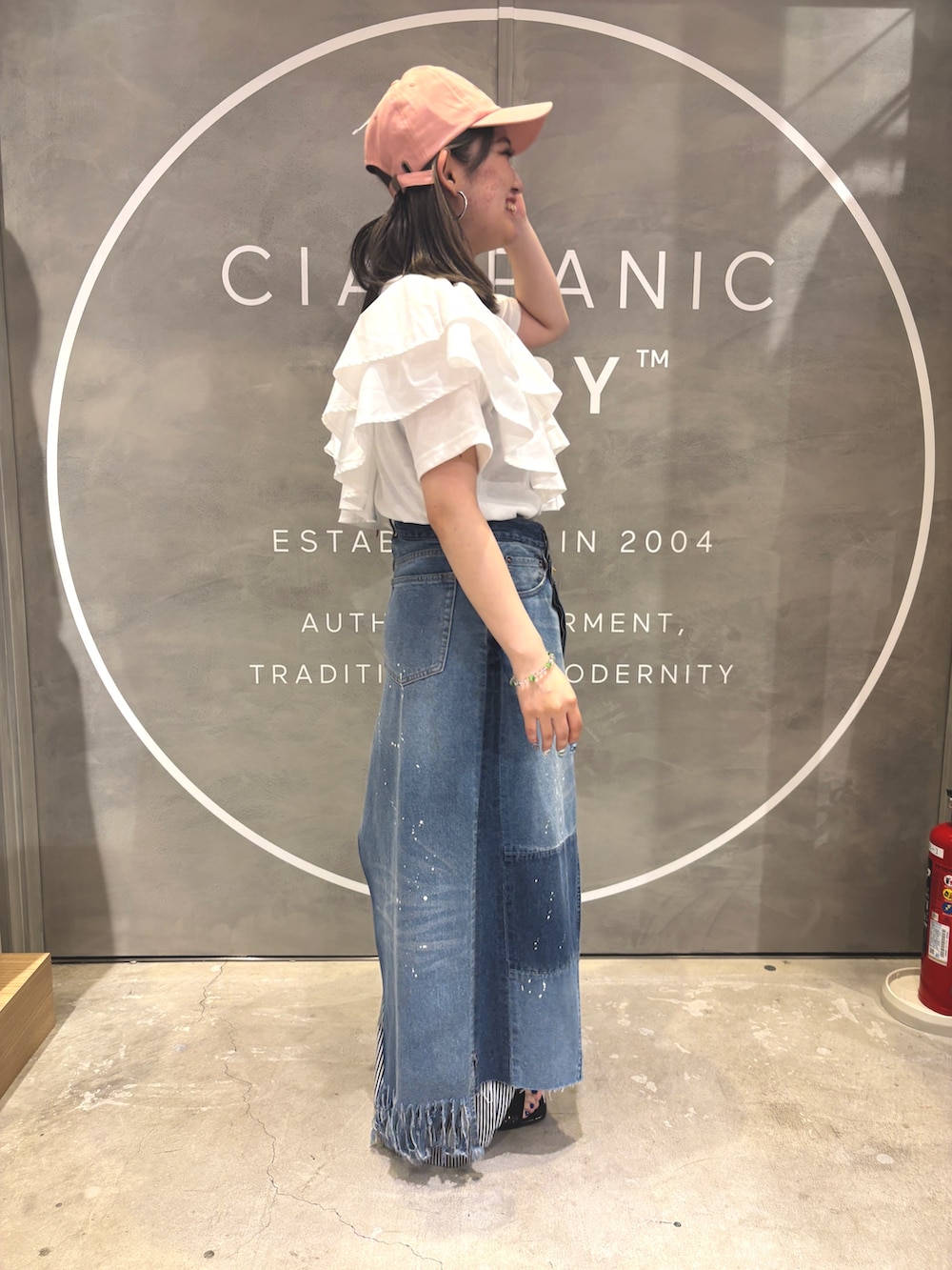 ホワイト系のTシャツ/カットソー、ブラウン系のトートバッグ、ブラック系のサンダルを着用したレディースの夏コーディネートの2枚目の写真