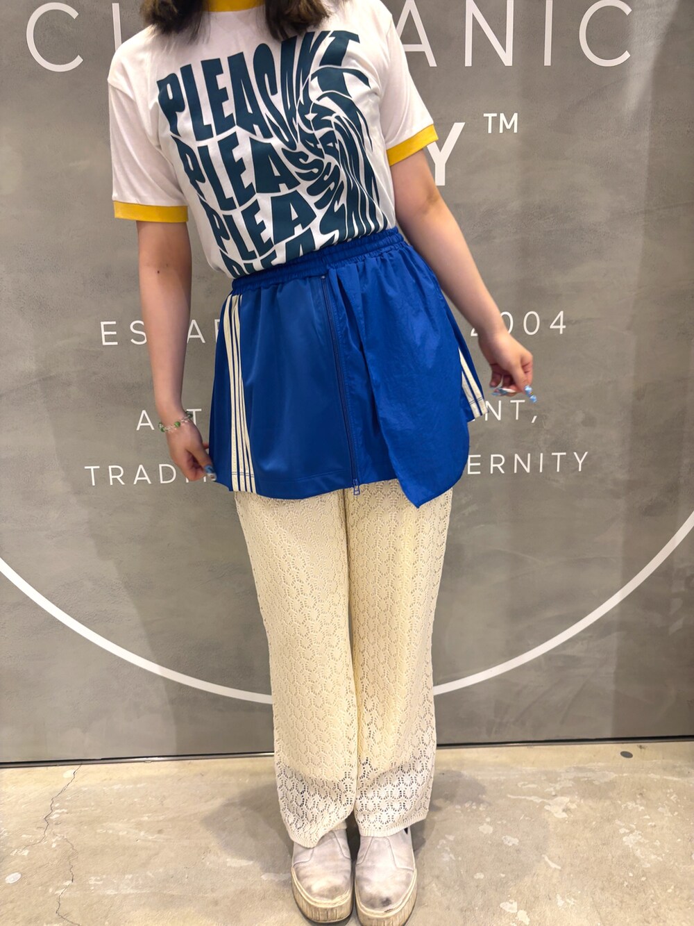 ブルー系のスカート、ホワイト系のパンツ、イエロー系のTシャツ/カットソーを着用したレディースの夏コーディネートの2枚目の写真