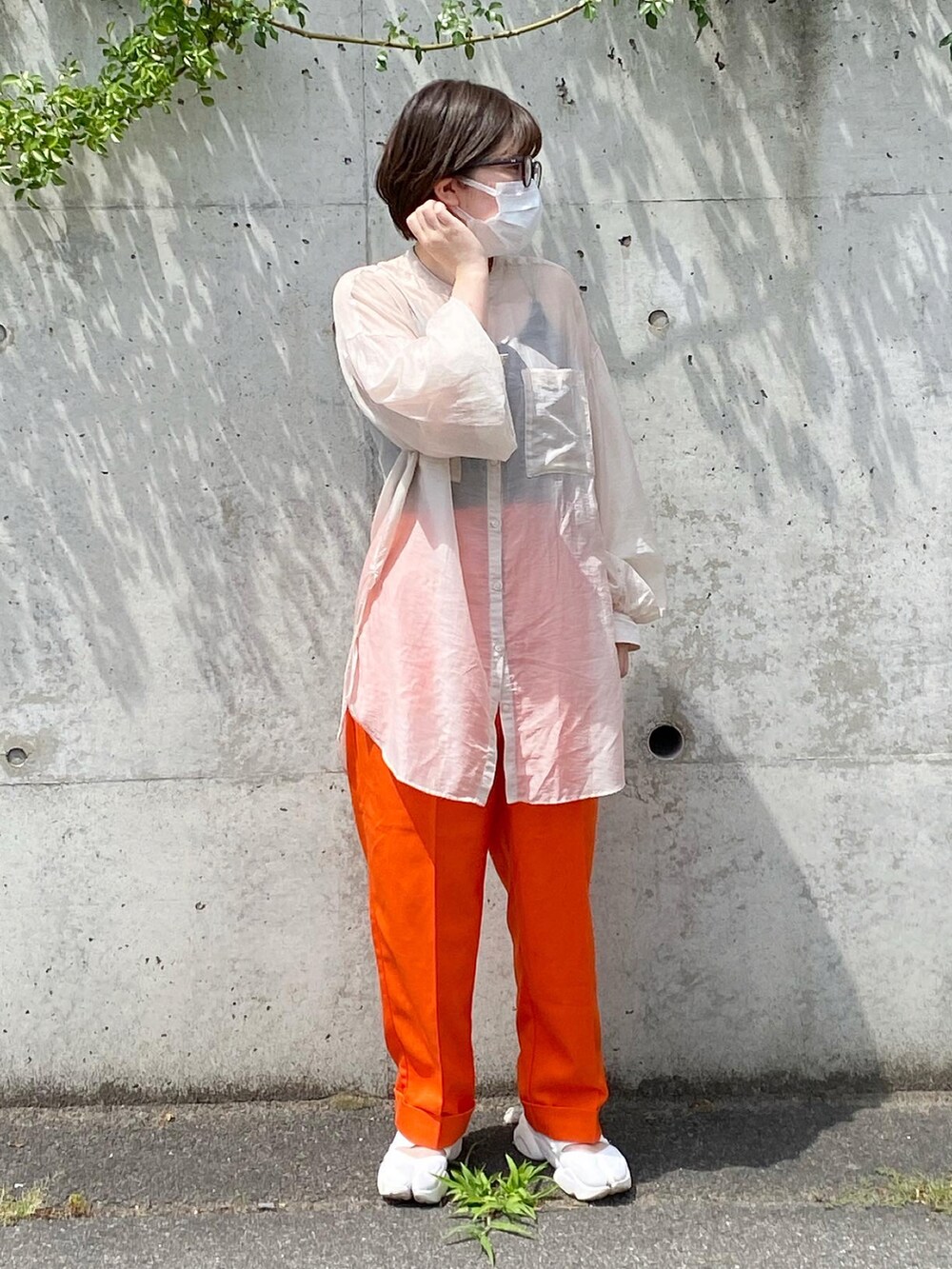 ホワイト系のサンダル、オレンジ系のその他パンツ、ベージュ系のシャツ/ブラウスを着用したレディースの夏コーディネートの2枚目の写真