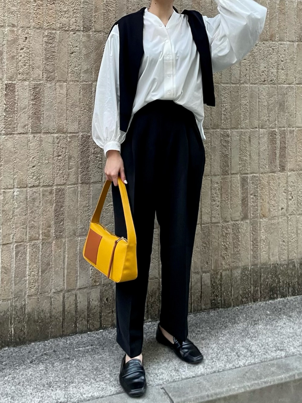 イエロー系のショルダーバッグ、ブラック系のスラックス、ブラック系のローファーを着用したレディースの春コーディネートの3枚目の写真