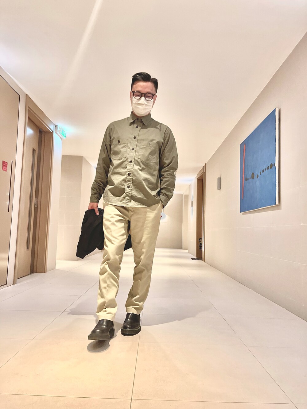 ブラック系のジャケット/アウター、ベージュ系のパンツ、ブラック系のシューズを着用したメンズの春コーディネートの5枚目の写真