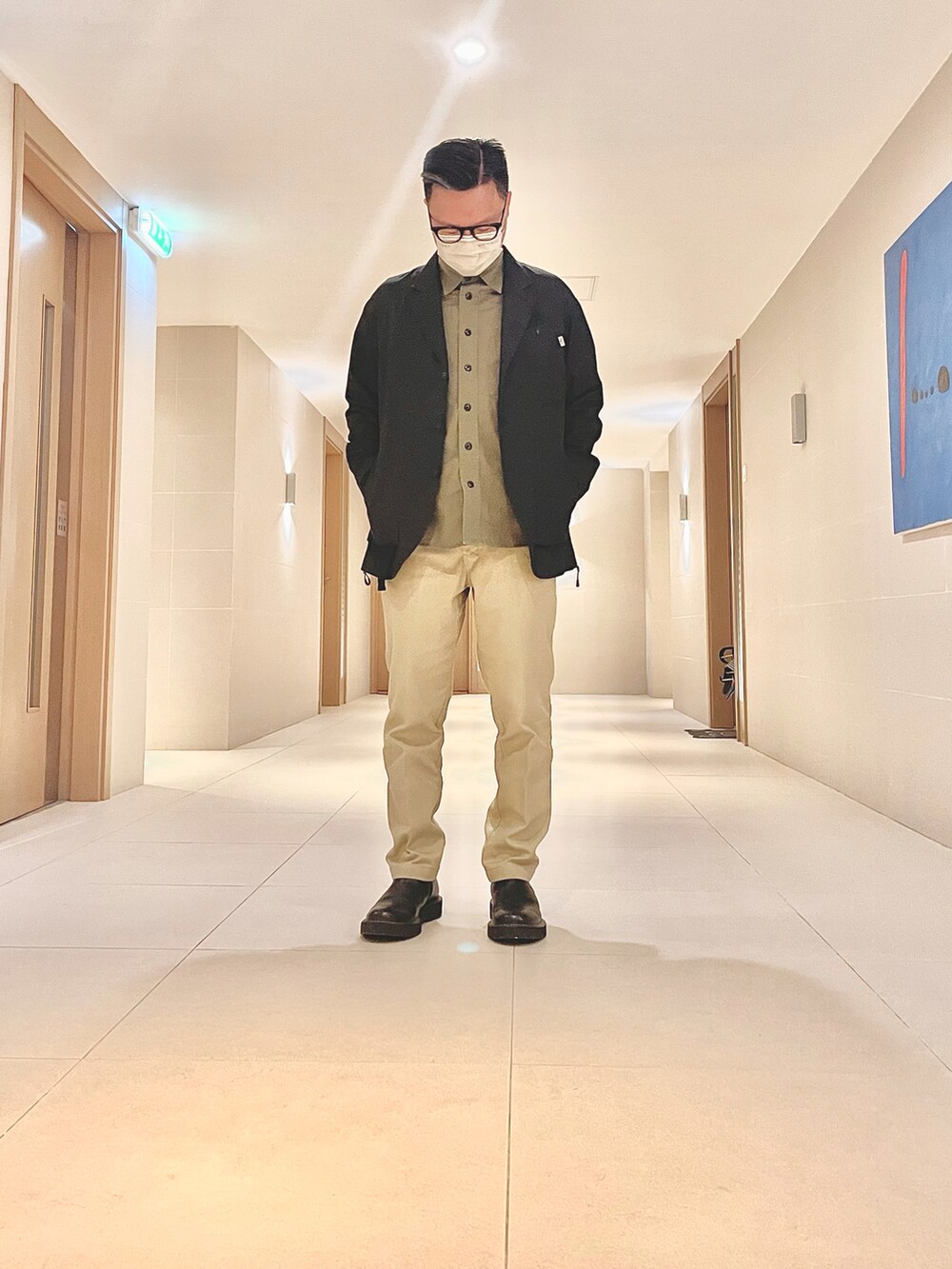 ブラック系のジャケット/アウター、ベージュ系のパンツ、ブラック系のシューズを着用したメンズの春コーディネートの2枚目の写真