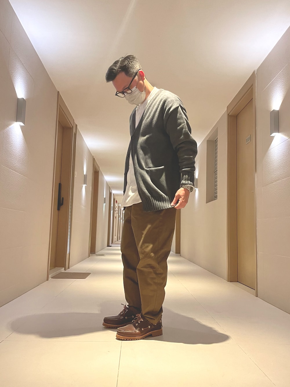 グレー系のジャケット/アウター、ホワイト系のトップス、ブラウン系のパンツを着用したメンズの冬コーディネートの2枚目の写真