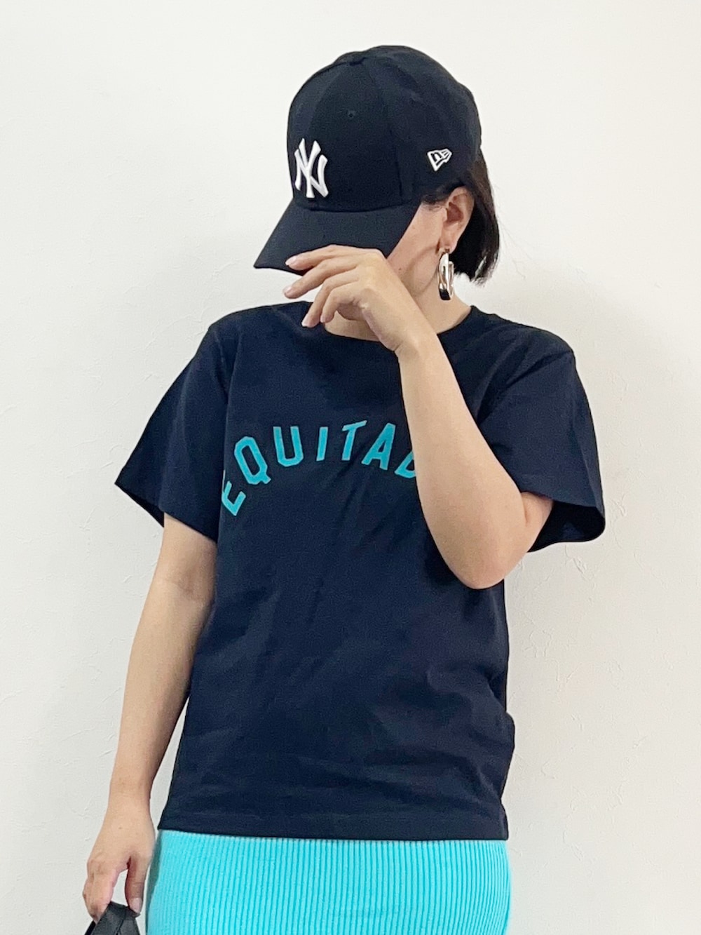 ブルー系のTシャツ/カットソー、ブルー系のスカート、ブラック系のショルダーバッグを着用したレディースの夏コーディネートの2枚目の写真