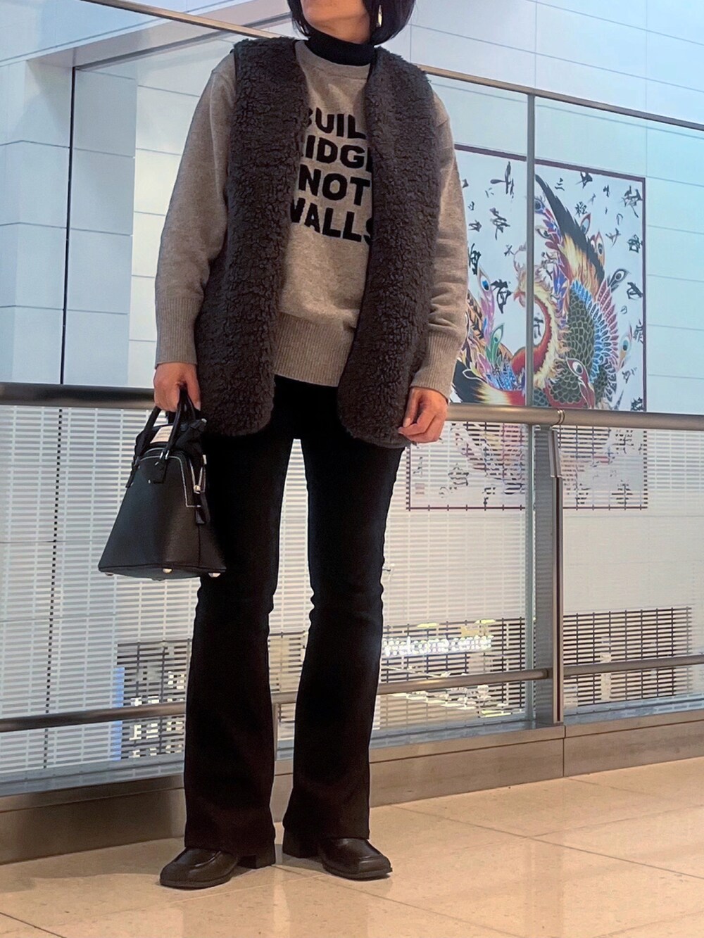 グレー系のニット/セーター、ブラック系のニット/セーター、グレー系のベストを着用したレディースの秋コーディネートの3枚目の写真