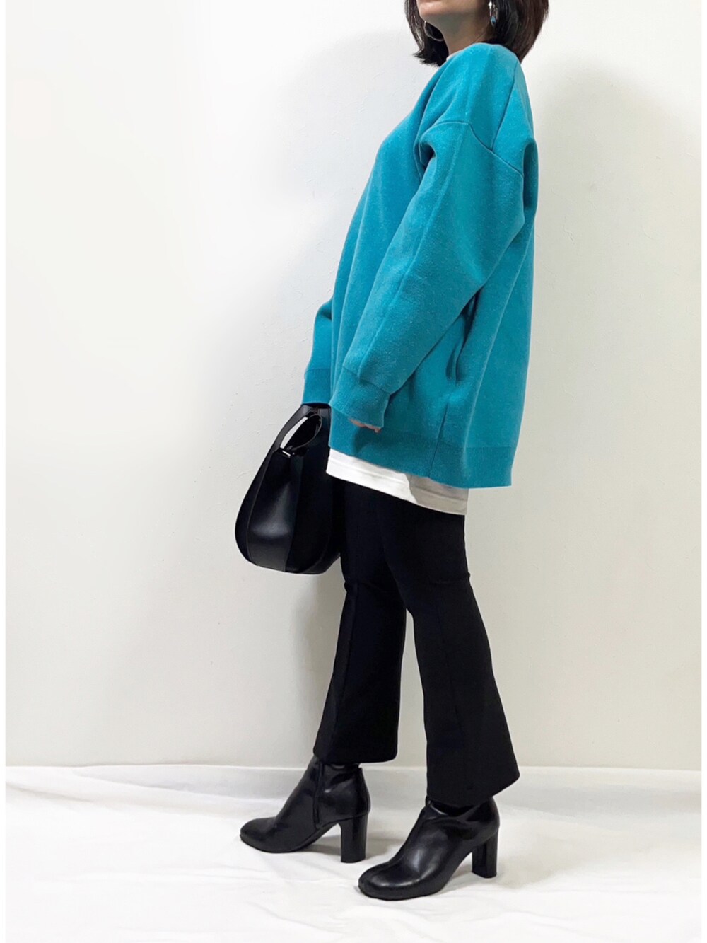 ホワイト系のTシャツ/カットソー、ブルー系のニット/セーター、ブラック系のパンツを着用したレディースの冬コーディネートの2枚目の写真