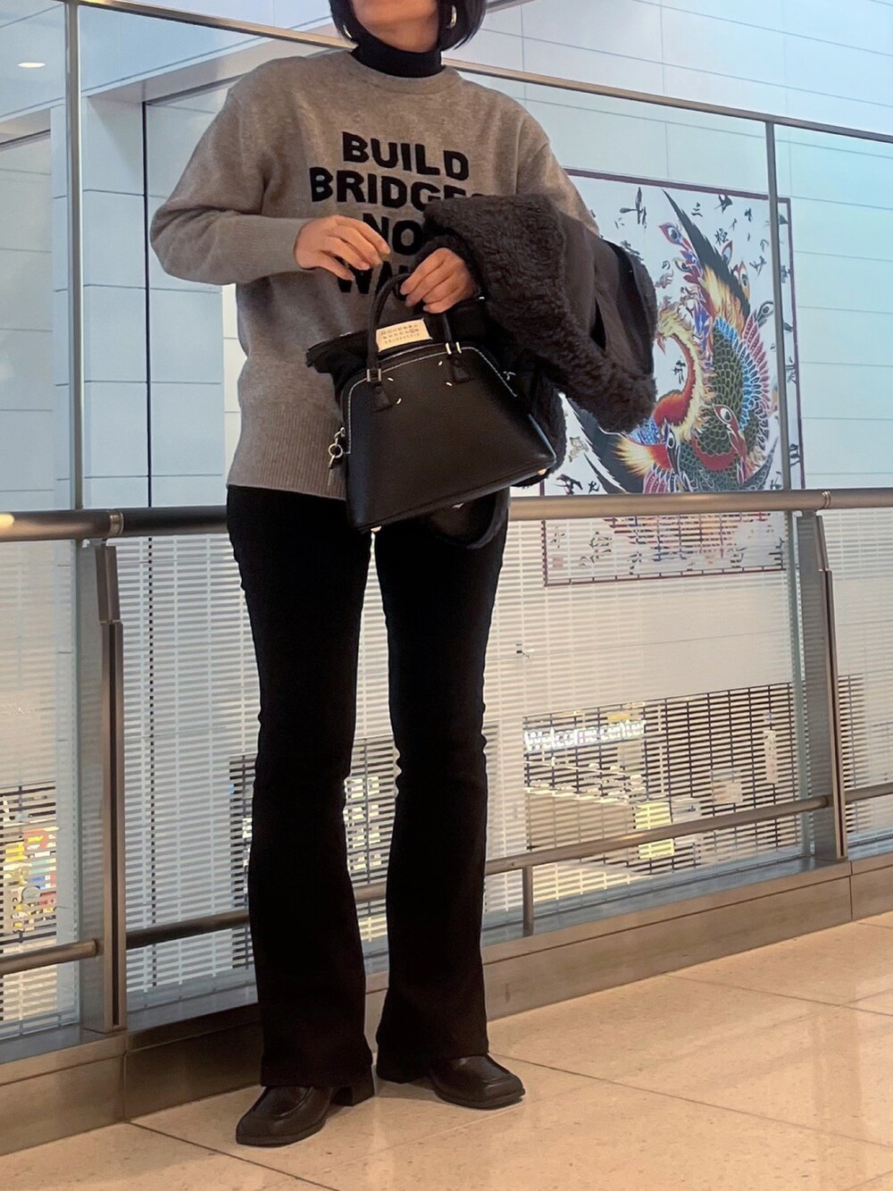 グレー系のニット/セーター、ブラック系のニット/セーター、グレー系のベストを着用したレディースの秋コーディネートの2枚目の写真