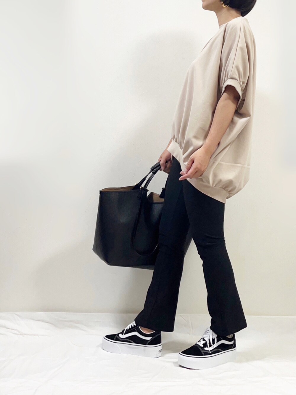 ベージュ系のTシャツ/カットソー、ブラック系のパンツ、ブラック系のトートバッグを着用したレディースの夏コーディネートの2枚目の写真