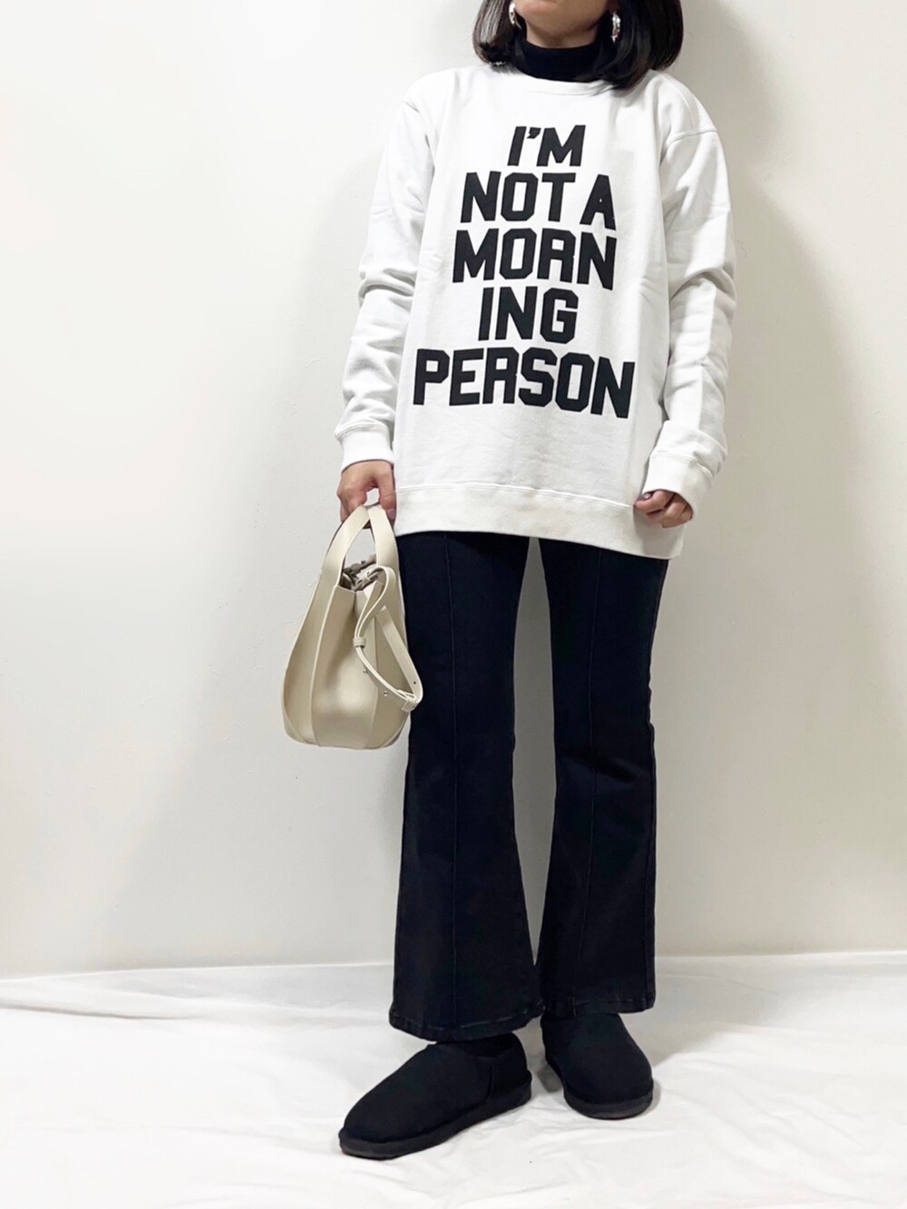 ブラック系のニット/セーター、ホワイト系のTシャツ/カットソー、ブラック系のダウンジャケット/コートを着用したレディースの冬コーディネートの2枚目の写真