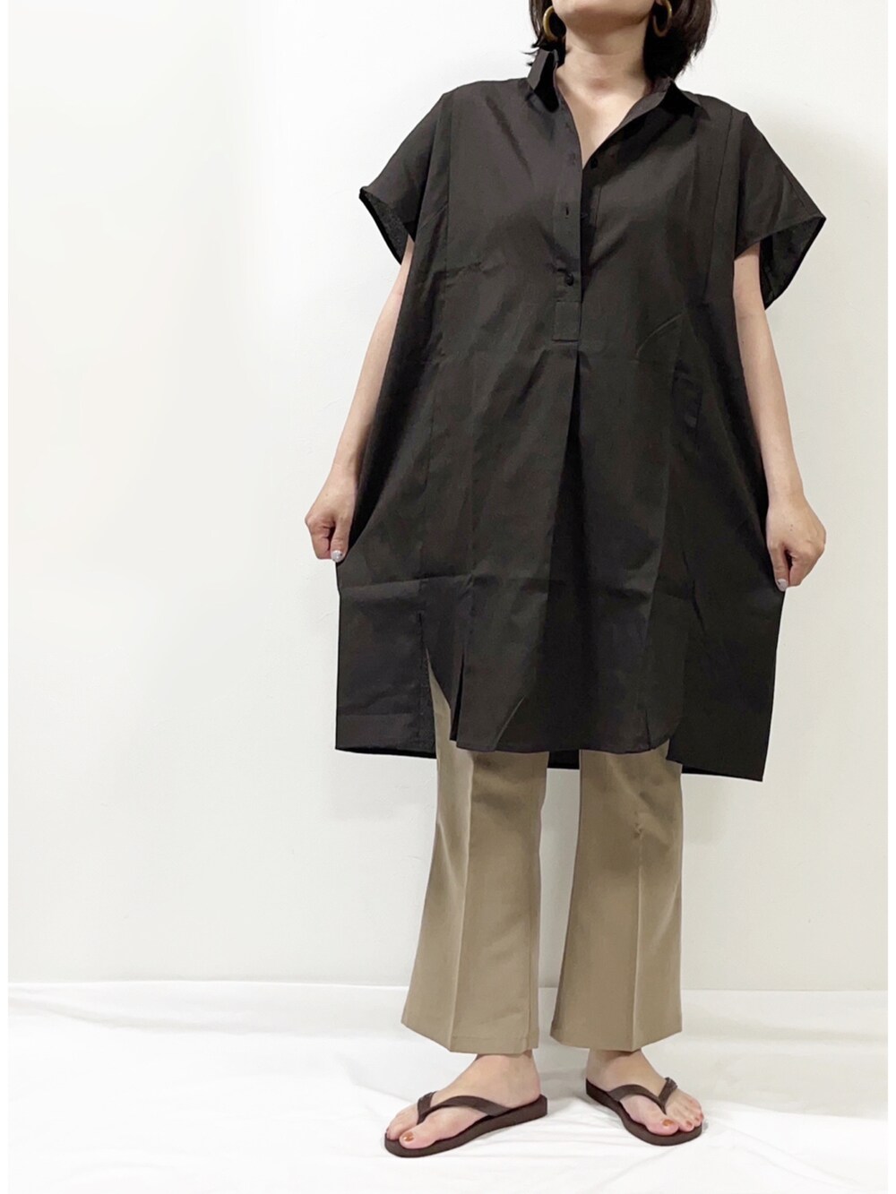 ブラウン系のシャツワンピース、ベージュ系のパンツ、ブラウン系のバッグを着用したレディースの春コーディネートの2枚目の写真