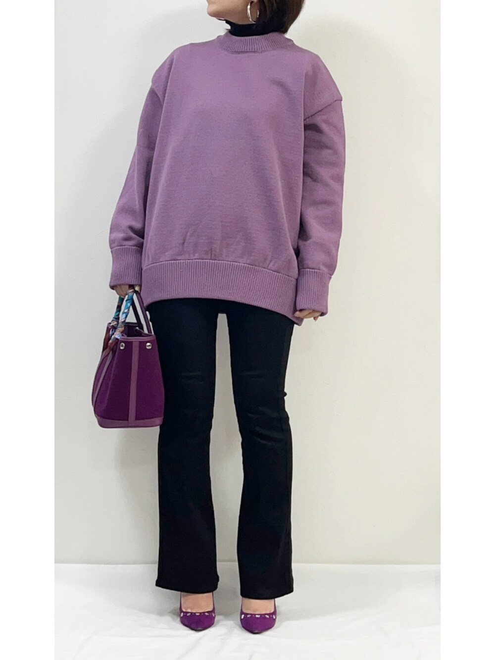 ブラック系のニット/セーター、パープル系のニット/セーター、ブラック系のダウンジャケット/コートを着用したレディースの冬コーディネートの2枚目の写真