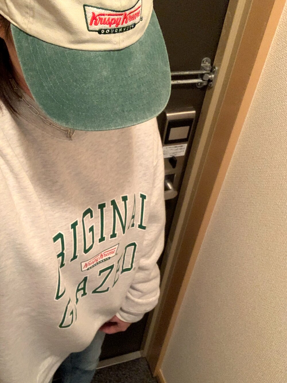 グレー系のスウェット、ブルー系のデニムパンツ、グリーン系のキャップを着用したレディースの冬コーディネートの2枚目の写真