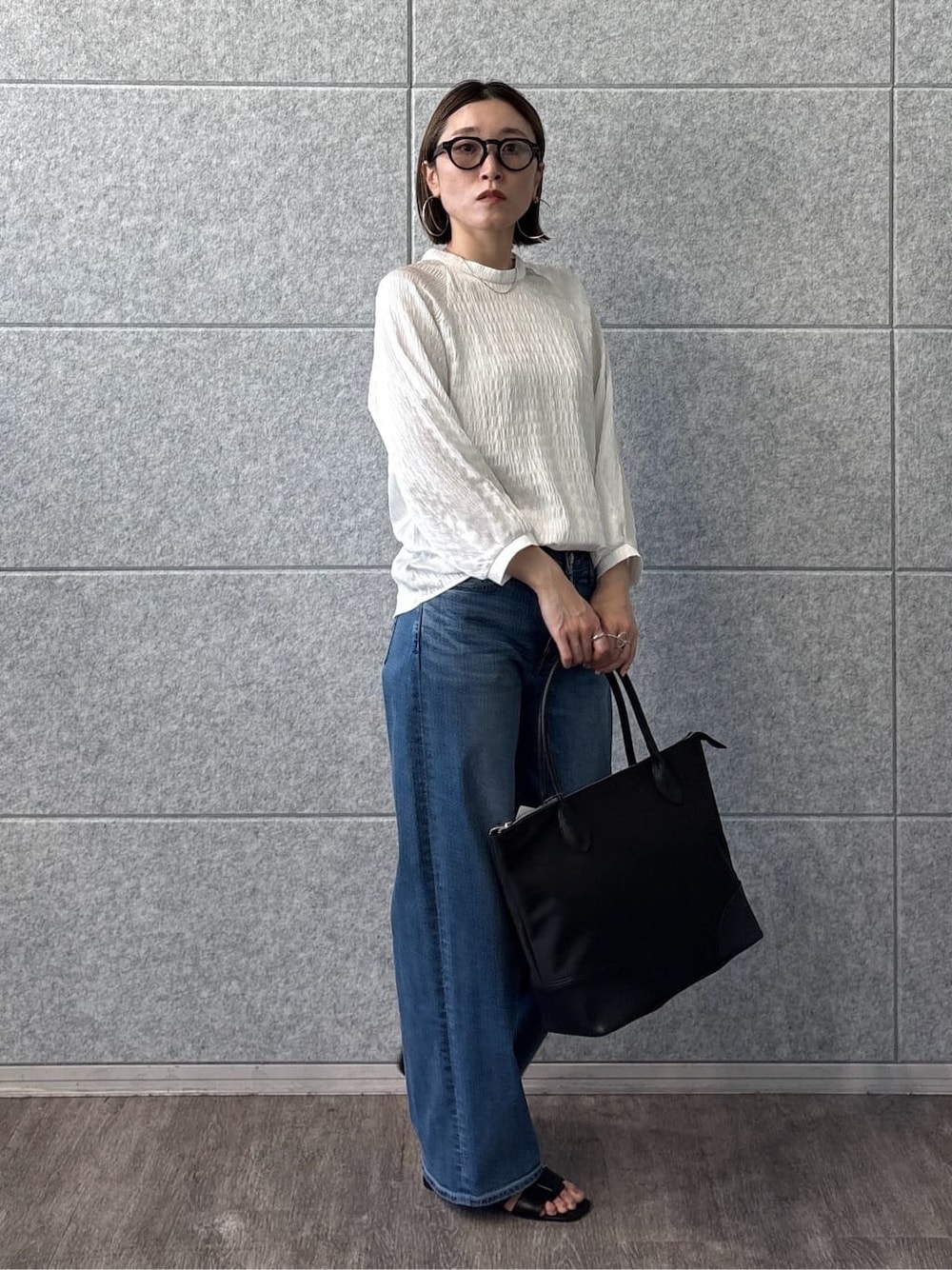 ホワイト系のシャツ/ブラウス、ブルー系のデニムパンツ、ブラック系のサンダルを着用したレディースの春コーディネートの6枚目の写真