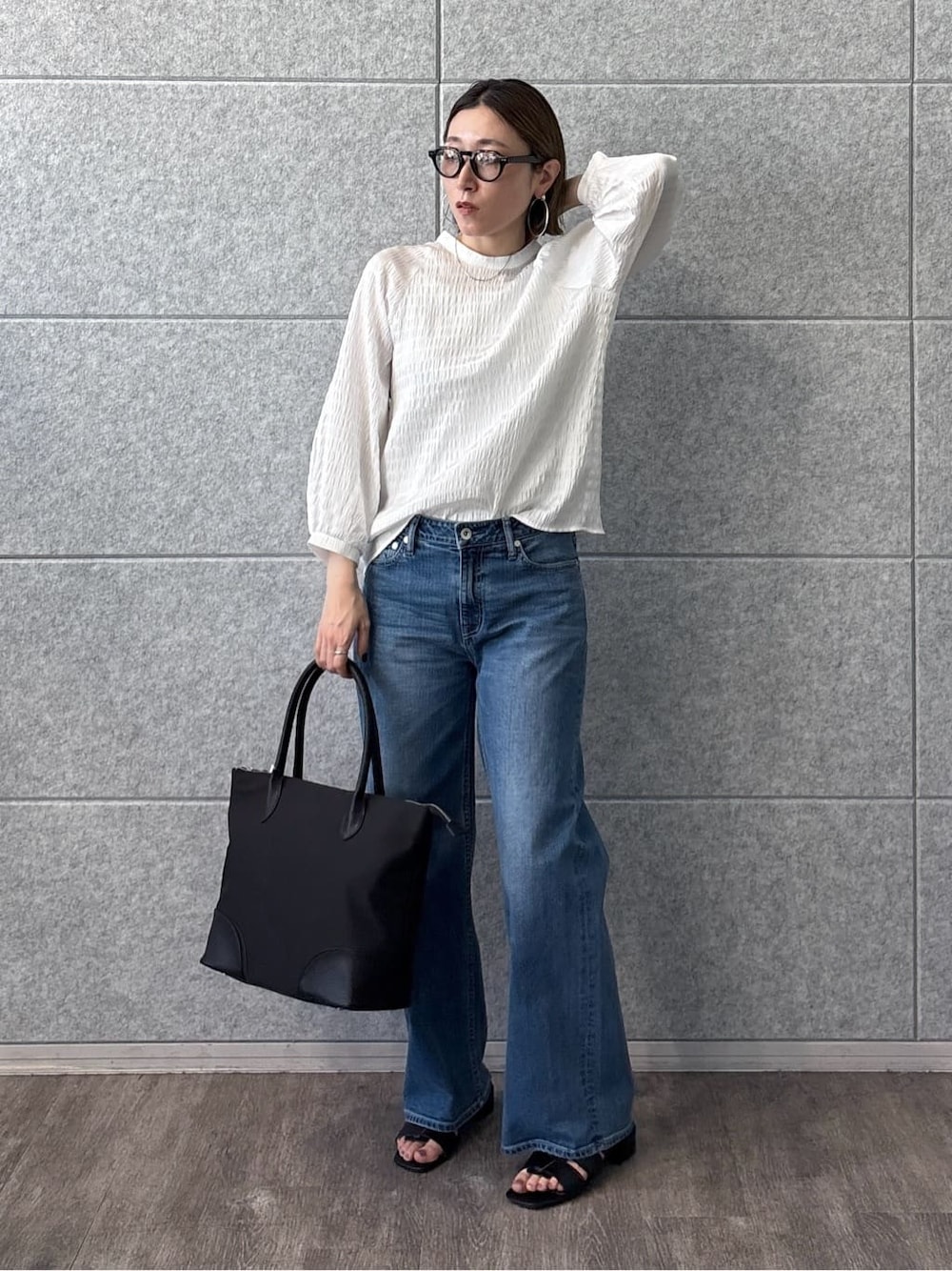 ホワイト系のシャツ/ブラウス、ブルー系のデニムパンツ、ブラック系のサンダルを着用したレディースの春コーディネートの2枚目の写真