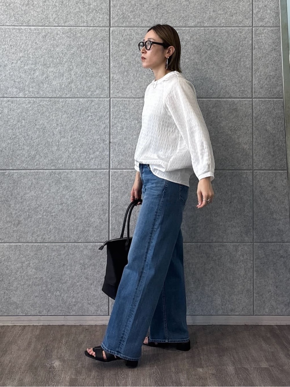 ホワイト系のシャツ/ブラウス、ブルー系のデニムパンツ、ブラック系のサンダルを着用したレディースの春コーディネートの4枚目の写真