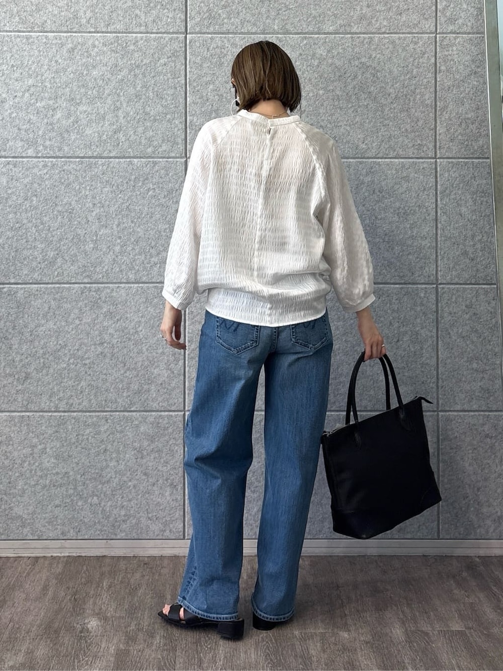 ホワイト系のシャツ/ブラウス、ブルー系のデニムパンツ、ブラック系のサンダルを着用したレディースの春コーディネートの5枚目の写真