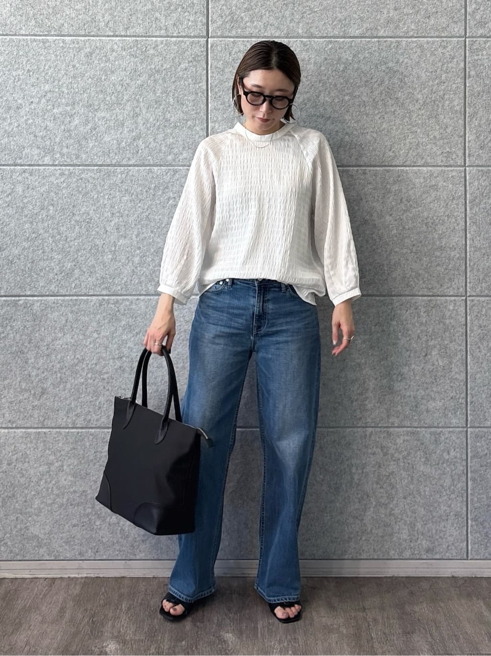 ホワイト系のシャツ/ブラウス、ブルー系のデニムパンツ、ブラック系のサンダルを着用したレディースの春コーディネートの7枚目の写真
