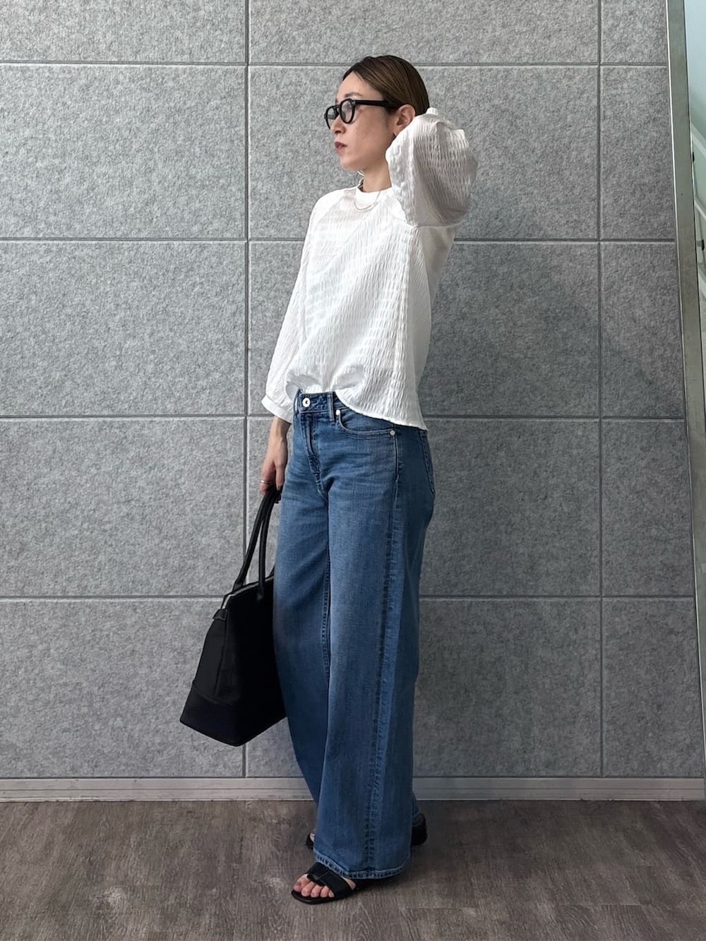 ホワイト系のシャツ/ブラウス、ブルー系のデニムパンツ、ブラック系のサンダルを着用したレディースの春コーディネートの3枚目の写真