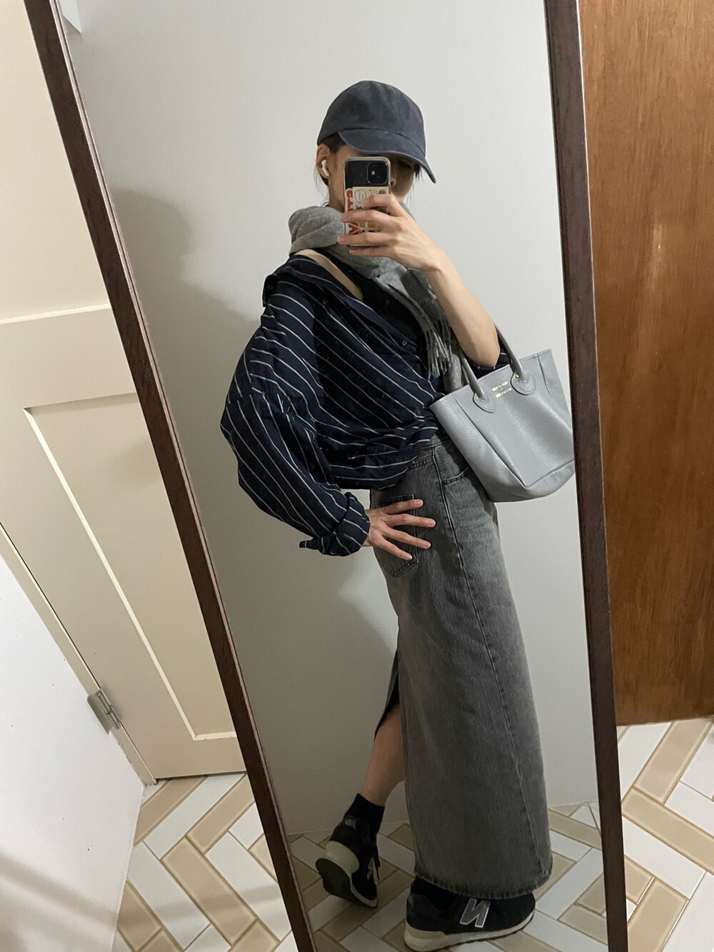 グレー系のトートバッグ、ブルー系のシャツ/ブラウス、グレー系のデニムスカートを着用したレディースの秋コーディネートの2枚目の写真