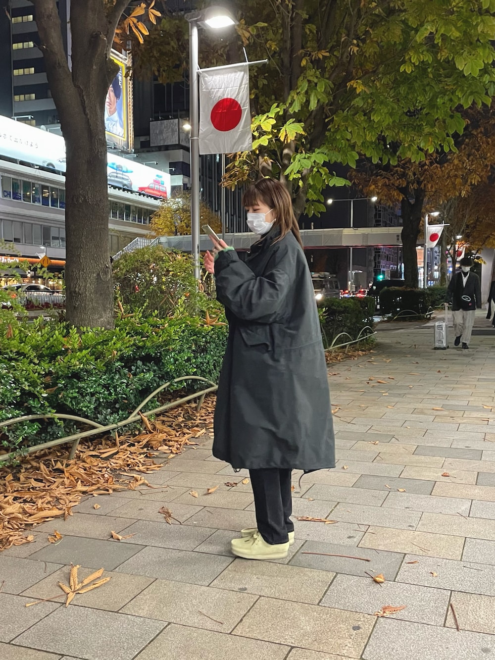 ブラック系のモッズコート、シルバー系のハンドバッグ、ブラック系のデニムパンツを着用したレディースの冬コーディネートの2枚目の写真