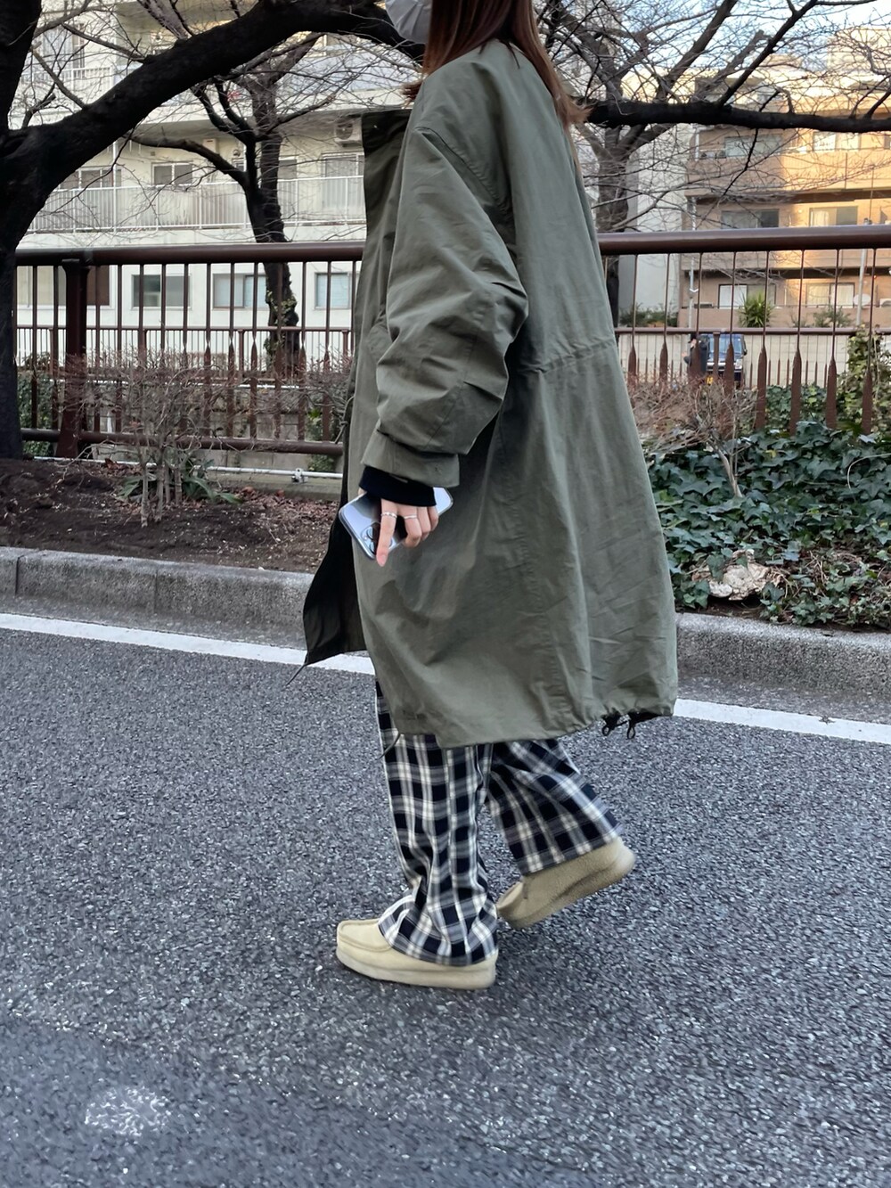 グリーン系のモッズコート、ベージュ系のモカシン/デッキシューズ、ブラック系のスウェットを着用したレディースの冬コーディネートの3枚目の写真