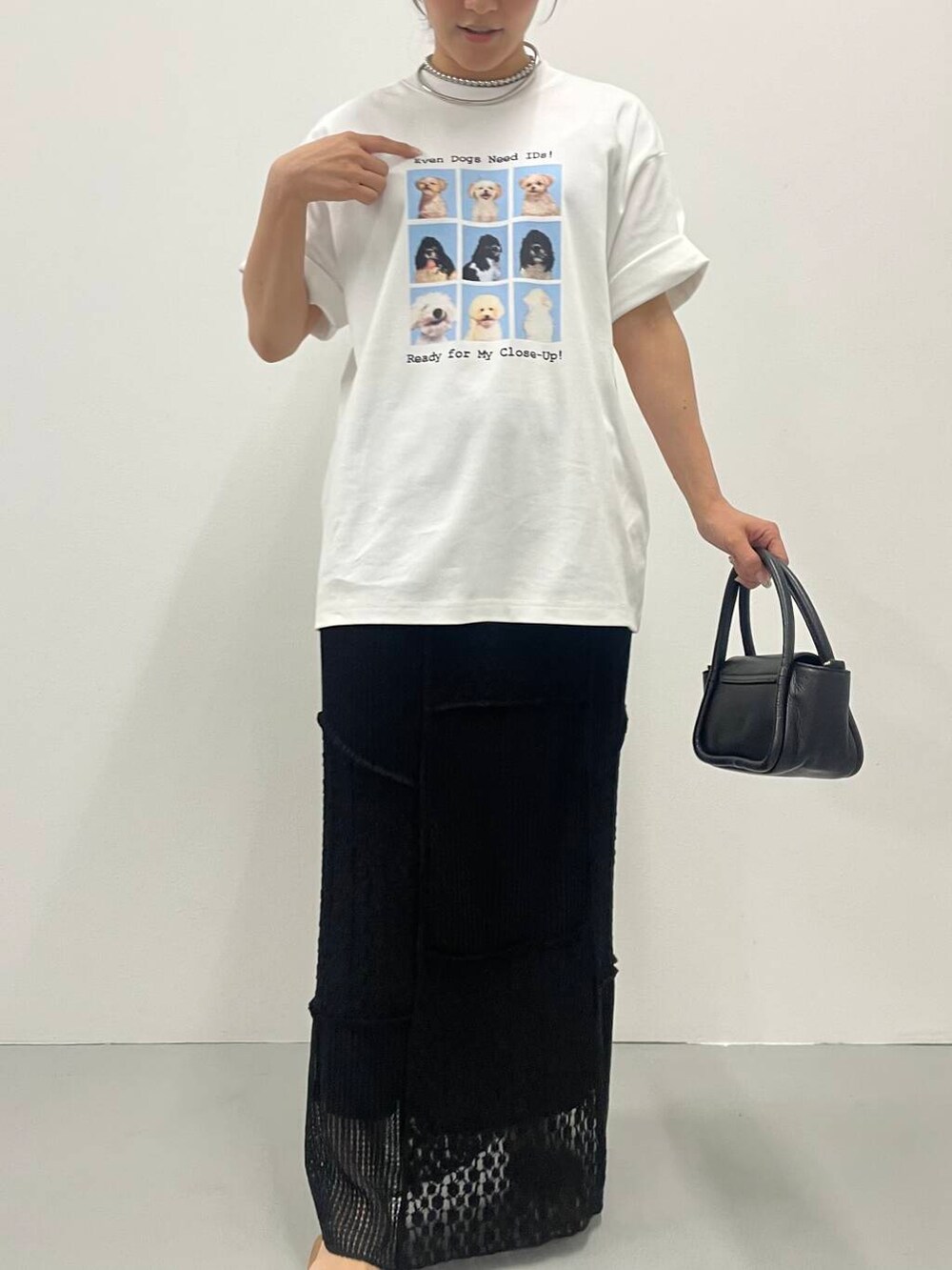 ブラック系のスカート、ホワイト系のTシャツ/カットソー、シルバー系のネックレスを着用したレディースの夏コーディネートの3枚目の写真