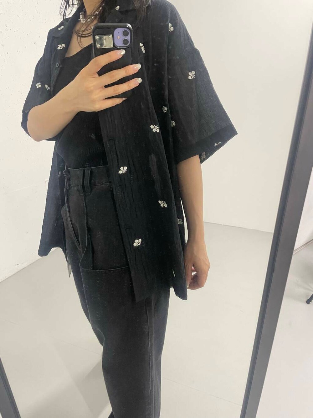 ブラック系のデニムパンツを着用したレディースの夏コーディネートの2枚目の写真