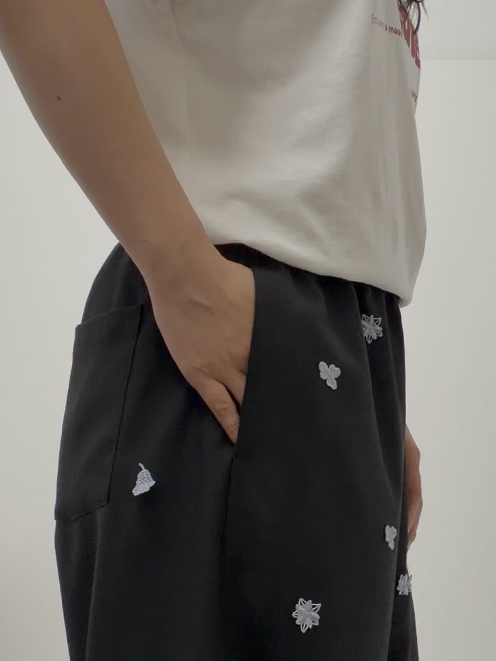 ホワイト系のTシャツ/カットソー、ブラック系のその他パンツ、ブラック系のサンダルを着用したレディースの夏コーディネートの2枚目の写真