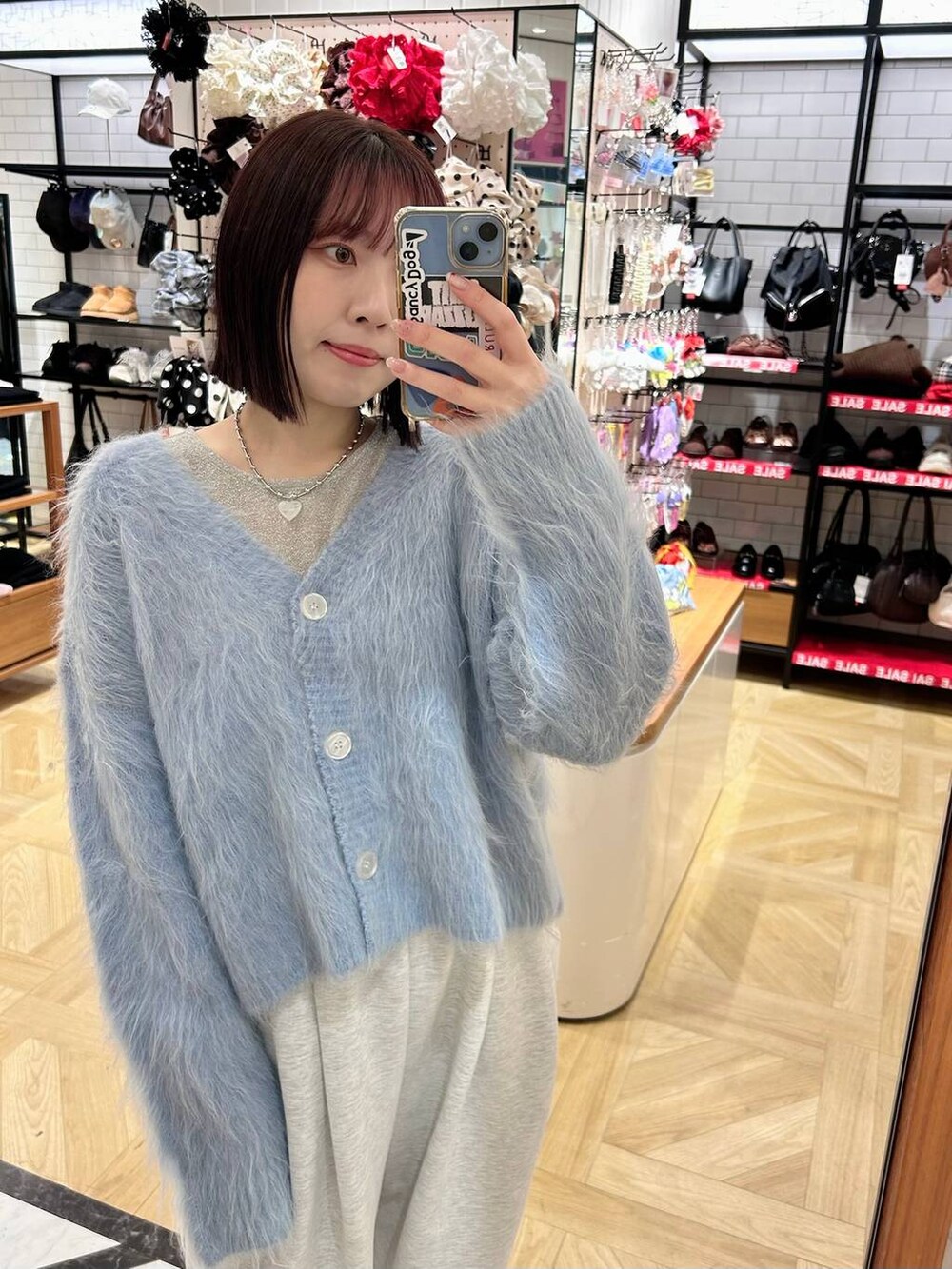 グレー系のスウェットパンツ、ブルー系のカーディガン/ボレロ、ホワイト系のTシャツ/カットソーを着用したレディースの冬コーディネートの3枚目の写真