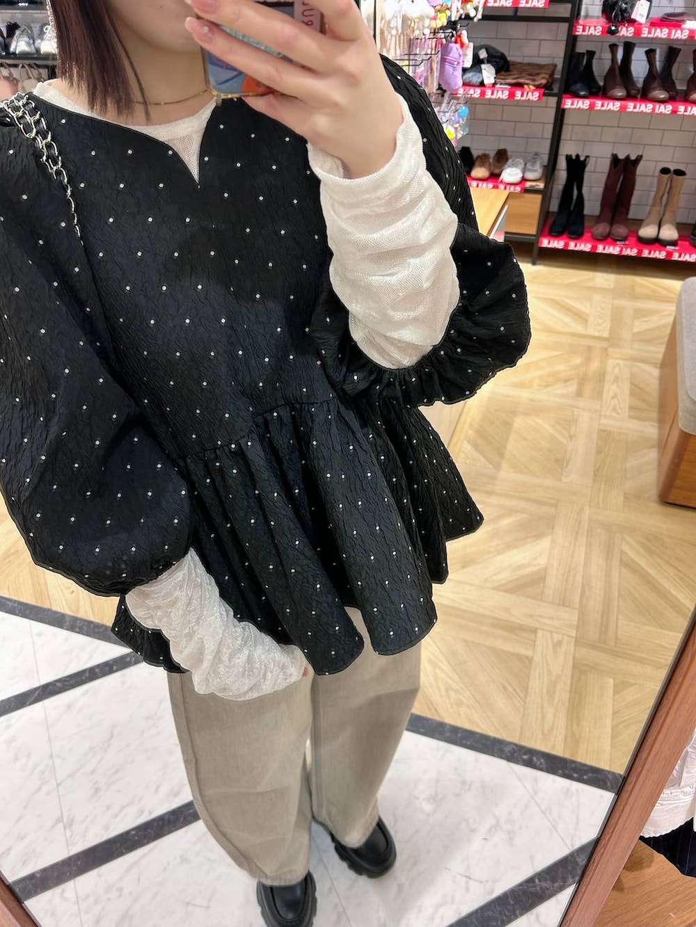 ベージュ系のデニムパンツ、ブラック系のショルダーバッグ、ブラック系のシャツ/ブラウスを着用したレディースの冬コーディネートの2枚目の写真