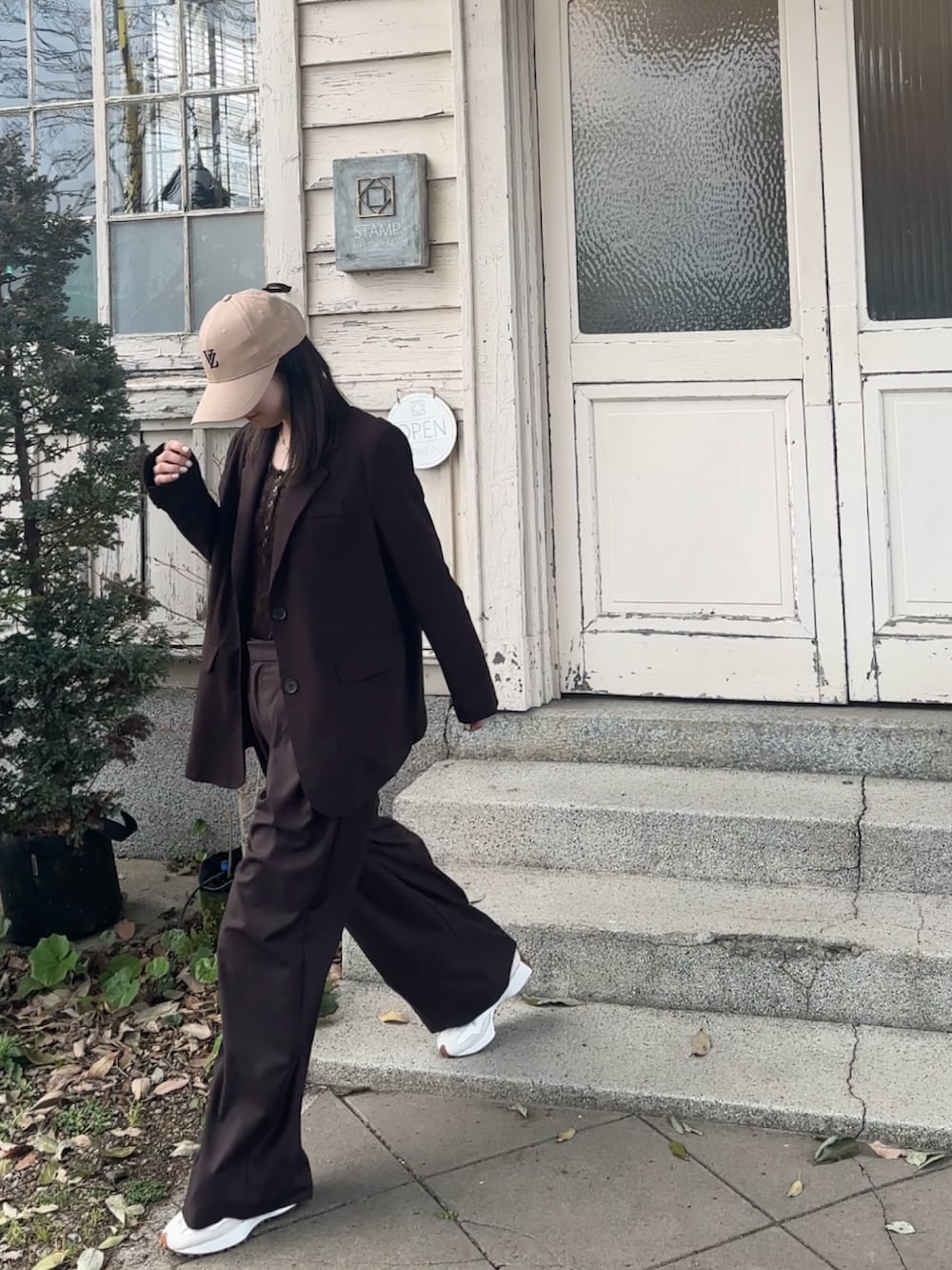 ブラウン系のスラックス、ブラウン系のスニーカー、ブラウン系のTシャツ/カットソーを着用したレディースの春コーディネートの4枚目の写真