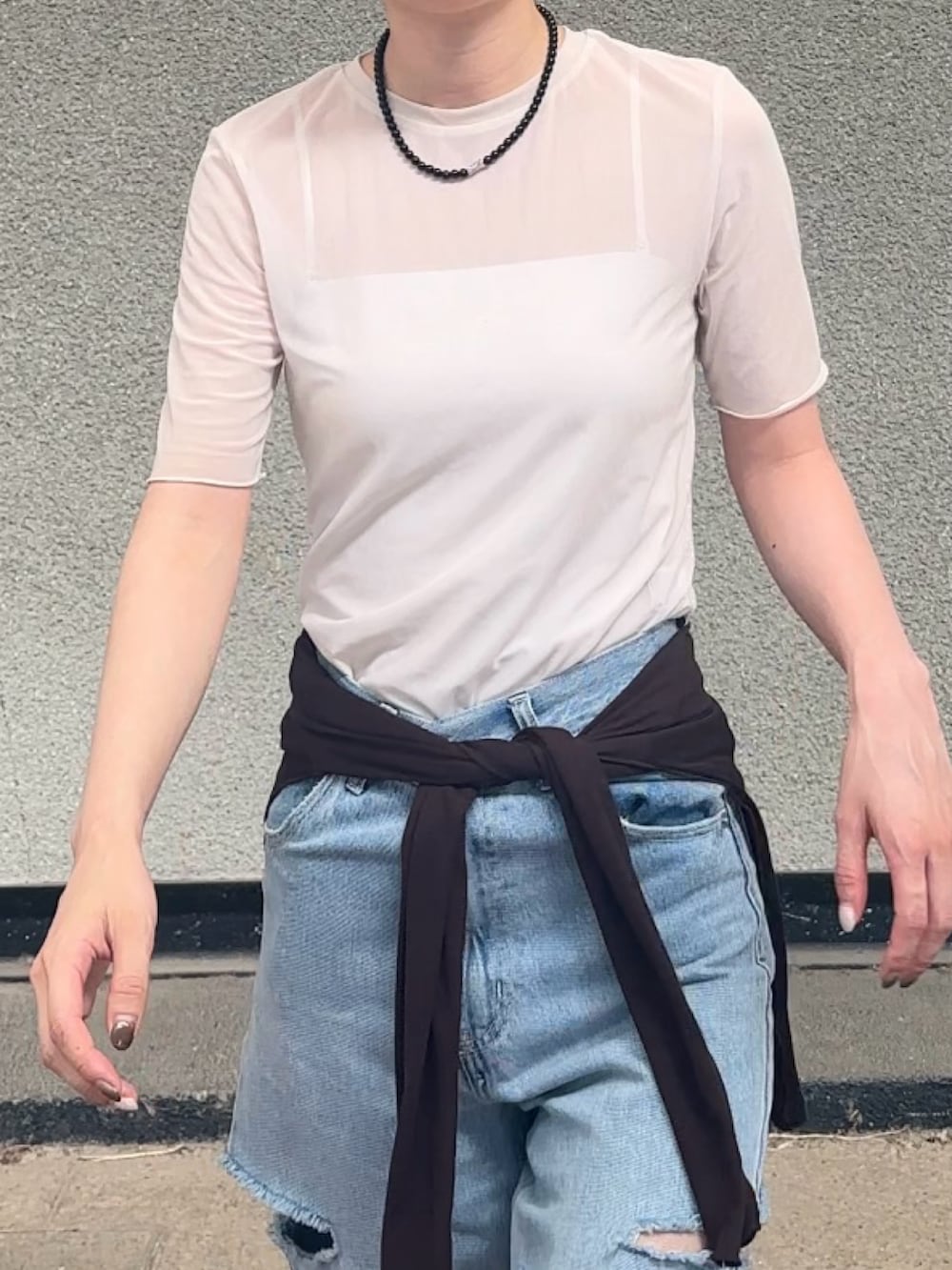 ホワイト系のトップス、ブラウン系のカーディガン/ボレロ、ブルー系のデニムパンツを着用したレディースの春コーディネートの2枚目の写真