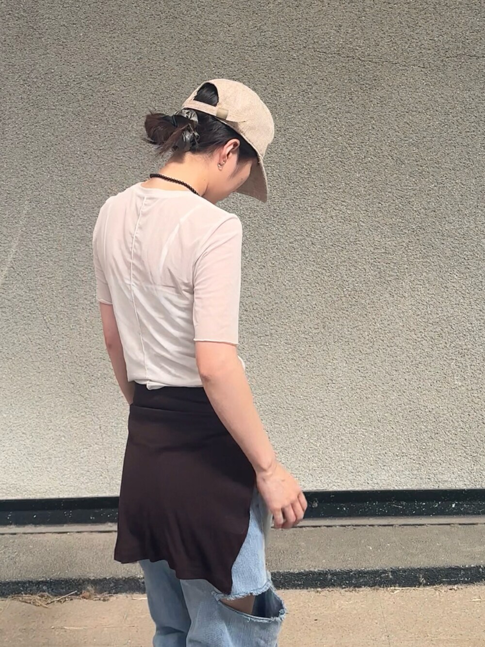ホワイト系のトップス、ブラウン系のカーディガン/ボレロ、ブルー系のデニムパンツを着用したレディースの春コーディネートの4枚目の写真