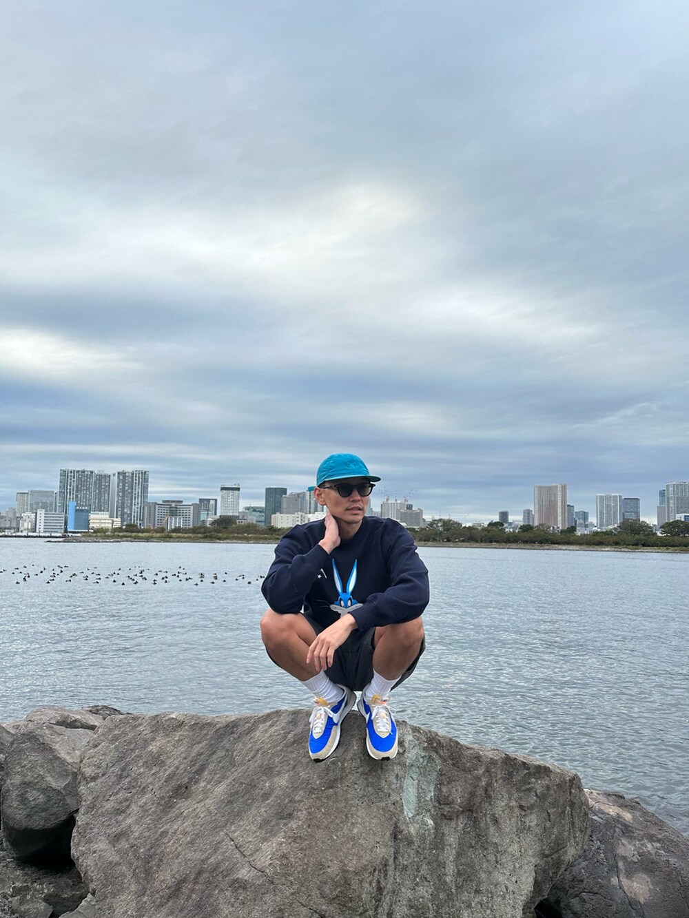 ブルー系のスニーカーを着用したメンズの秋コーディネートの2枚目の写真