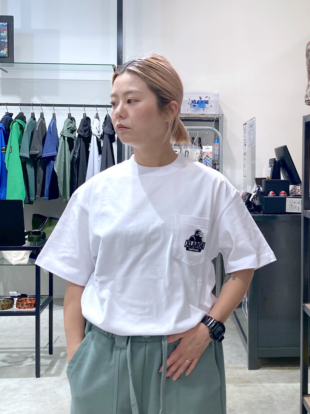 ホワイト系のTシャツ/カットソー、グリーン系のスウェットパンツ、グリーン系のショルダーバッグを着用したレディースの春コーディネートの3枚目の写真