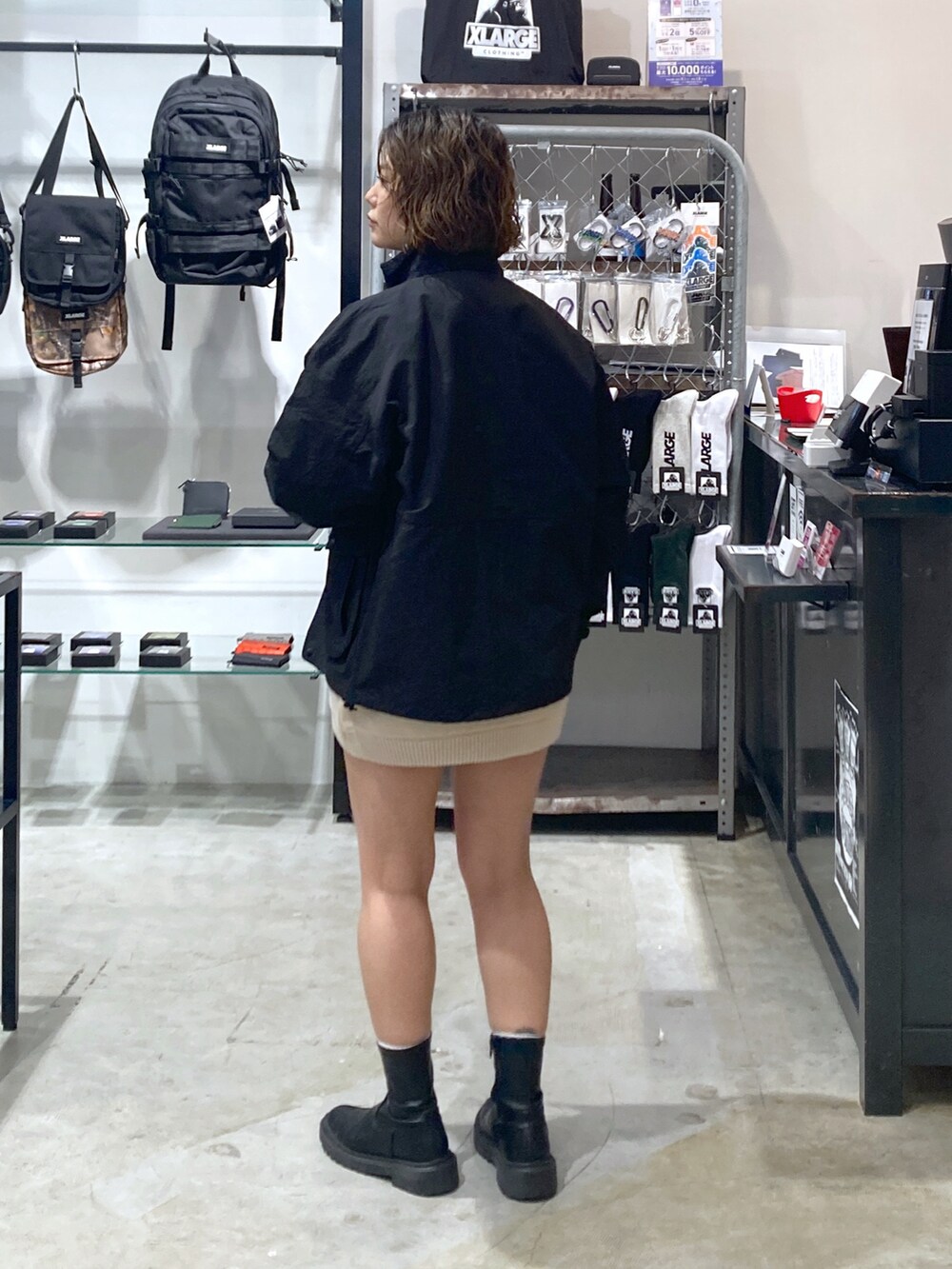 ブラック系のブルゾン、ベージュ系のニット/セーターを着用したレディースの春コーディネートの2枚目の写真