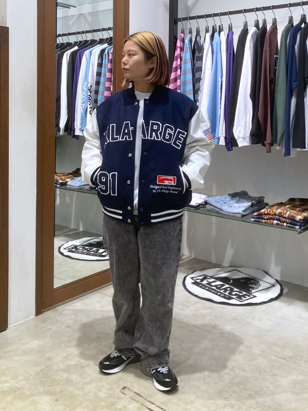 ブルー系のブルゾン、グレー系のデニムパンツ、グレー系のスウェットを着用したレディースの秋コーディネートの2枚目の写真