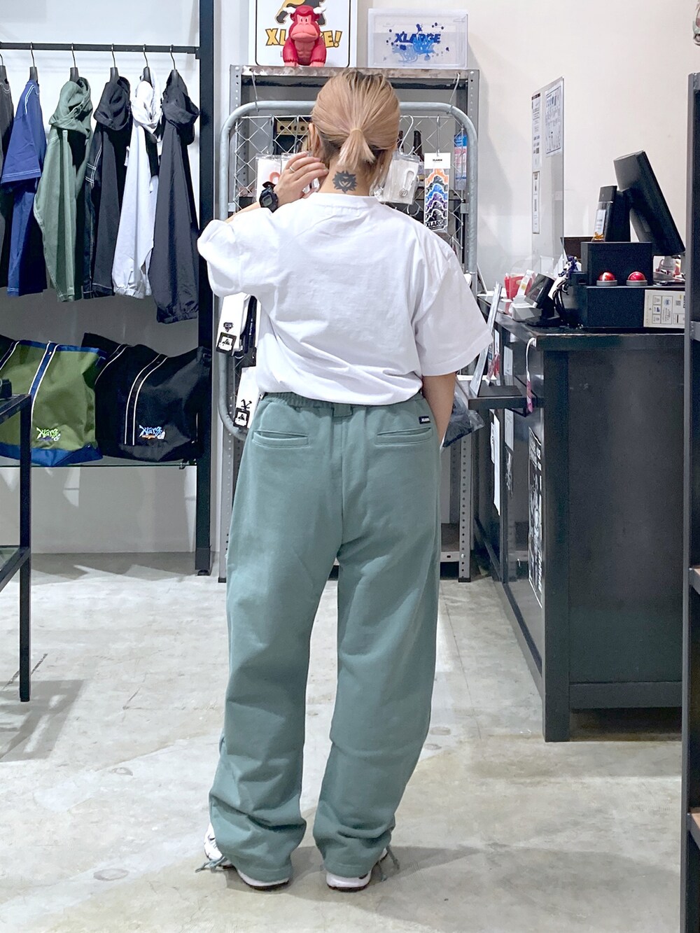 ホワイト系のTシャツ/カットソー、グリーン系のスウェットパンツ、グリーン系のショルダーバッグを着用したレディースの春コーディネートの2枚目の写真