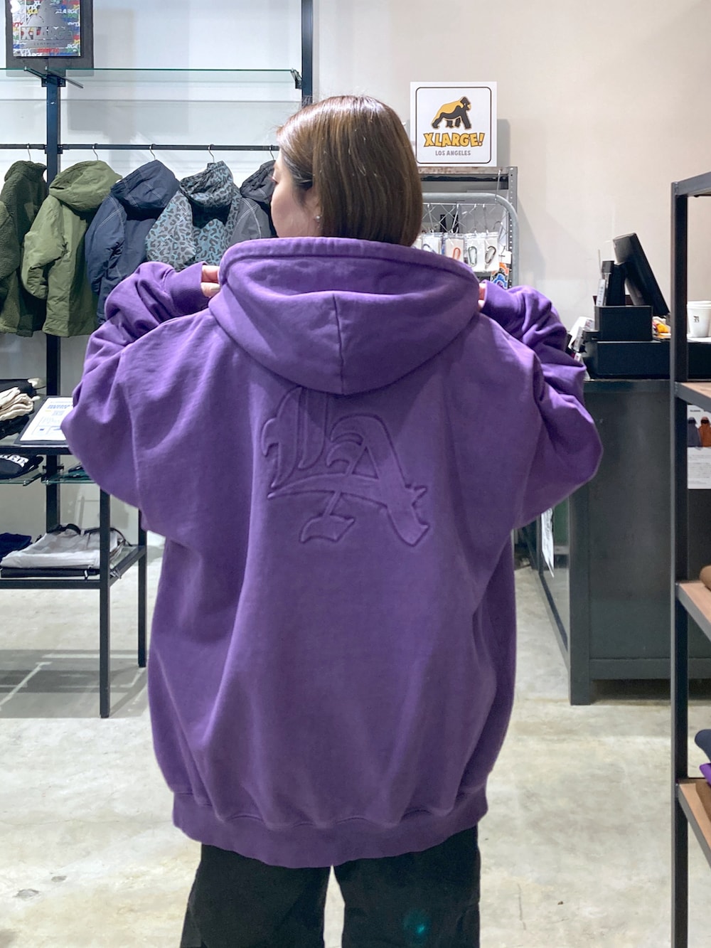 ブルー系のスウェット、パープル系のパーカー、ブラック系のカーゴパンツを着用したレディースの冬コーディネートの2枚目の写真