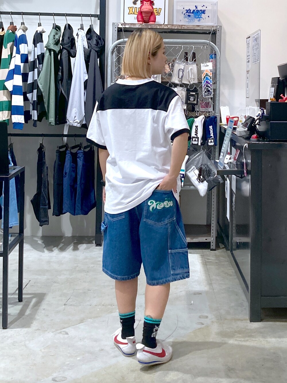 ブラック系のTシャツ/カットソー、ブルー系のその他パンツ、ホワイト系のショルダーバッグを着用したレディースの春コーディネートの4枚目の写真