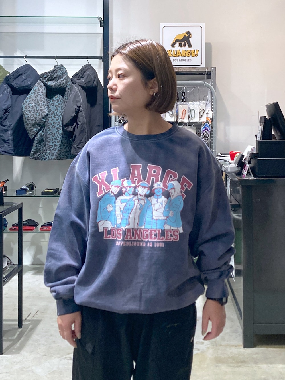 ブルー系のスウェット、パープル系のパーカー、ブラック系のカーゴパンツを着用したレディースの冬コーディネートの3枚目の写真