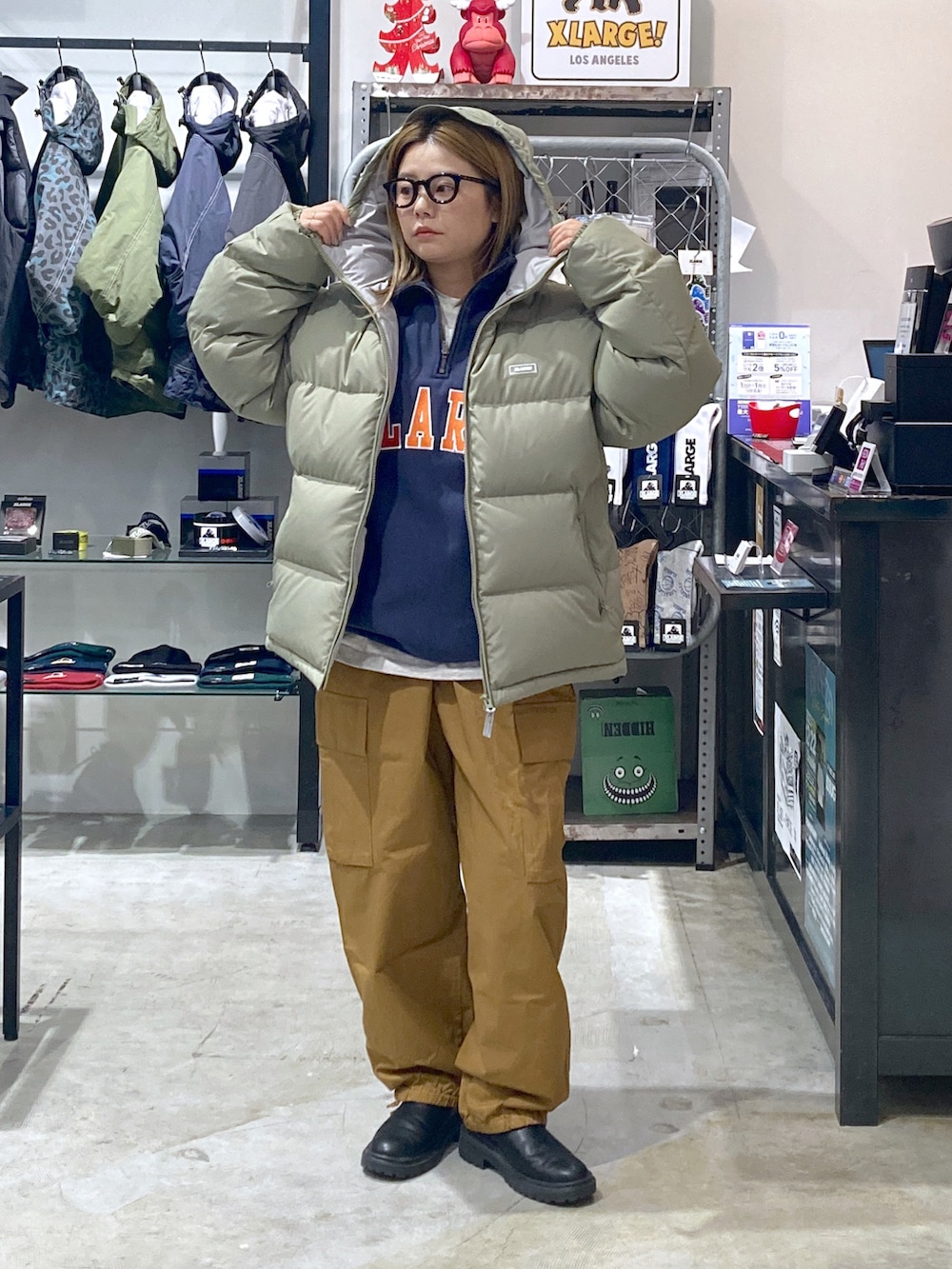 グリーン系のダウンジャケット/コート、ブルー系のスウェット、ブラウン系のカーゴパンツを着用したレディースの冬コーディネートの3枚目の写真