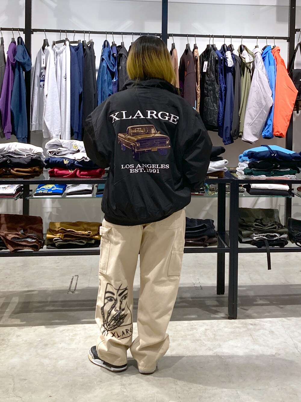 ブラック系のブルゾン、ホワイト系のTシャツ/カットソー、ベージュ系のその他パンツを着用したレディースの秋コーディネートの2枚目の写真