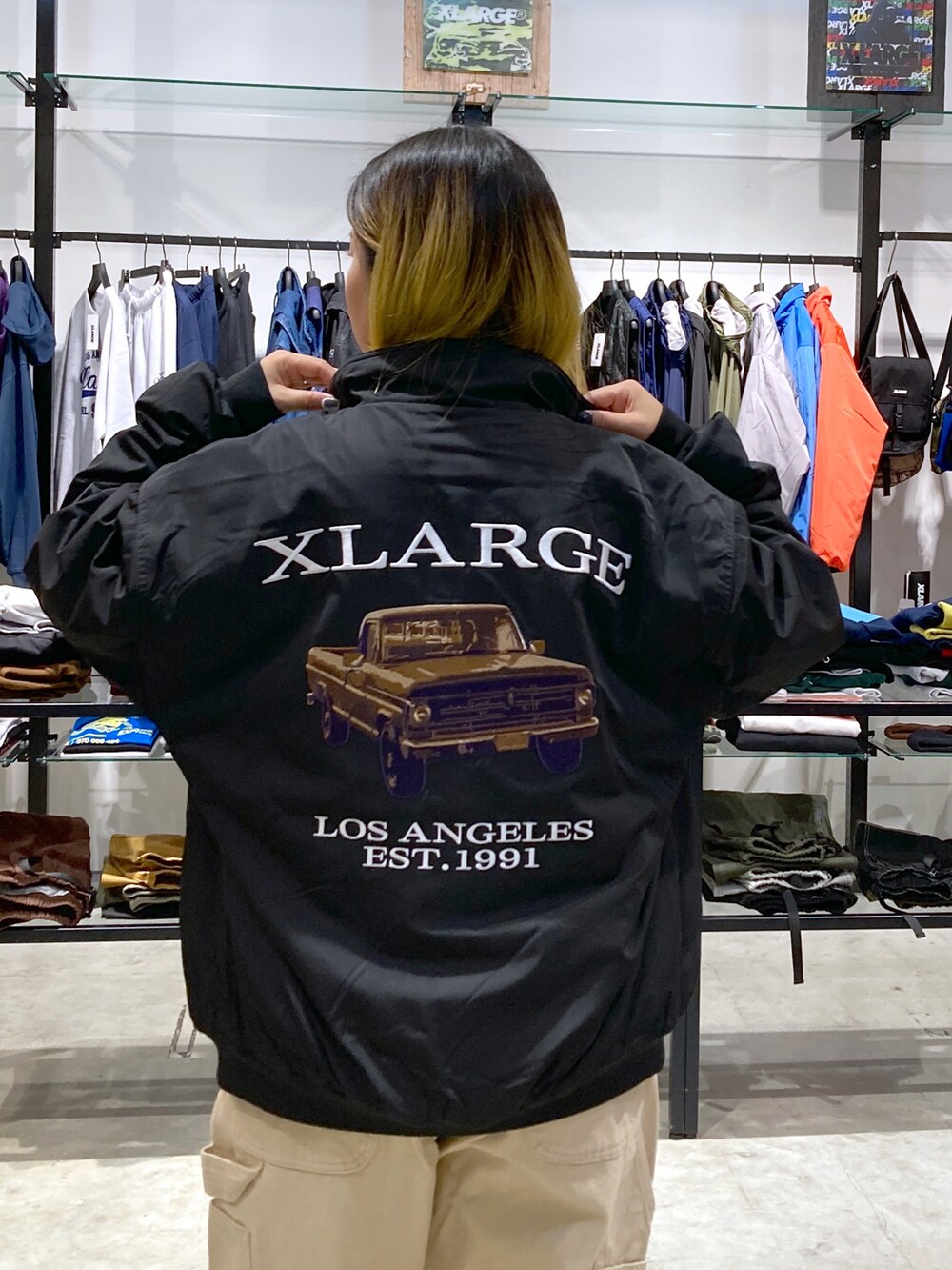 ブラック系のブルゾン、ホワイト系のTシャツ/カットソー、ベージュ系のその他パンツを着用したレディースの秋コーディネートの4枚目の写真