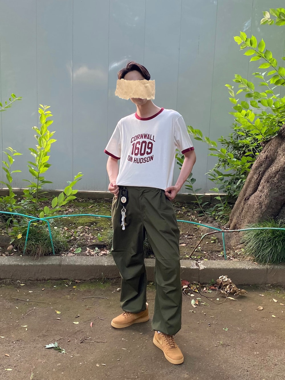 ホワイト系のTシャツ/カットソー、グリーン系のカーゴパンツ、ブラウン系のスニーカーを着用したメンズの夏コーディネートの2枚目の写真