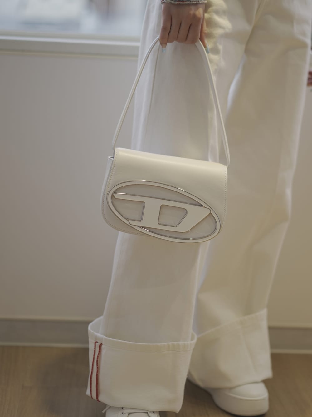 ブルー系のデニムジャケット、ホワイト系のショルダーバッグ、レッド系のTシャツ/カットソーを着用したレディースの春コーディネートの2枚目の写真