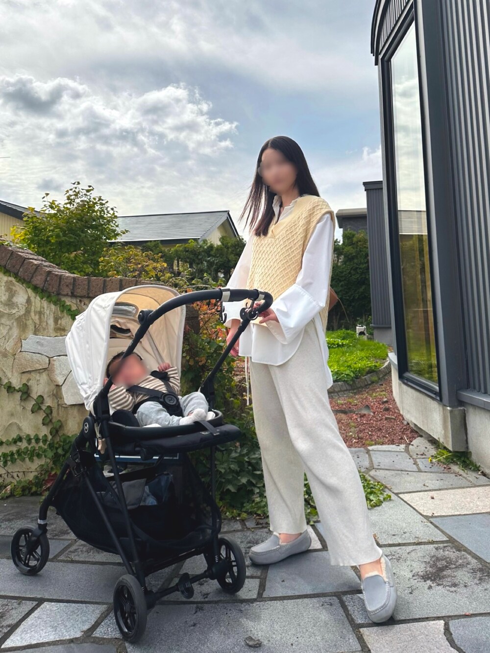 ベージュ系のベスト、ホワイト系のパンツ、ベージュ系のモカシン/デッキシューズを着用したレディースの秋コーディネートの2枚目の写真